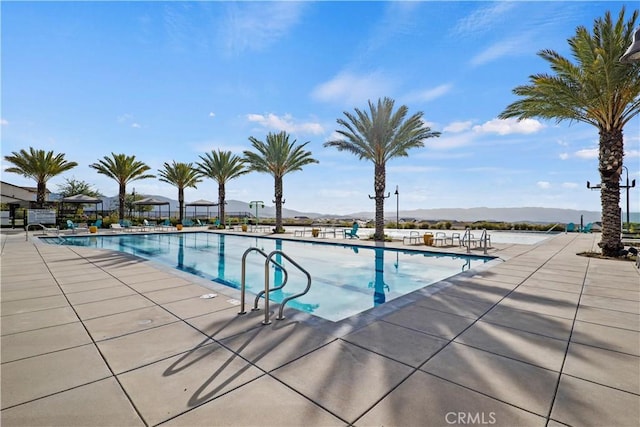 view of pool featuring a mountain view and a patio area