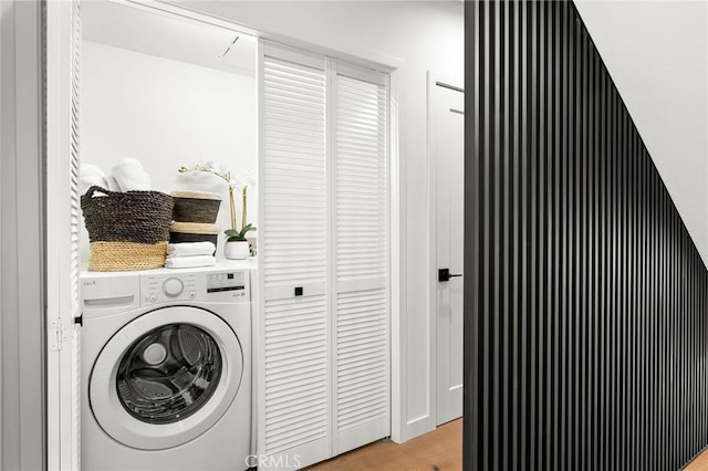 clothes washing area featuring washer / dryer and light hardwood / wood-style floors