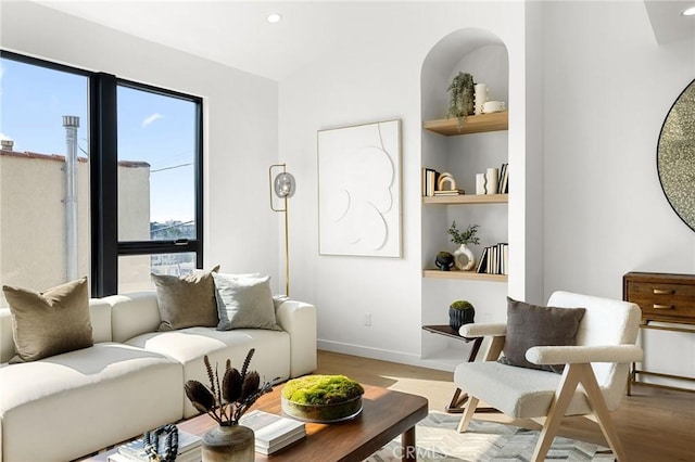 living room featuring built in features and light wood-type flooring