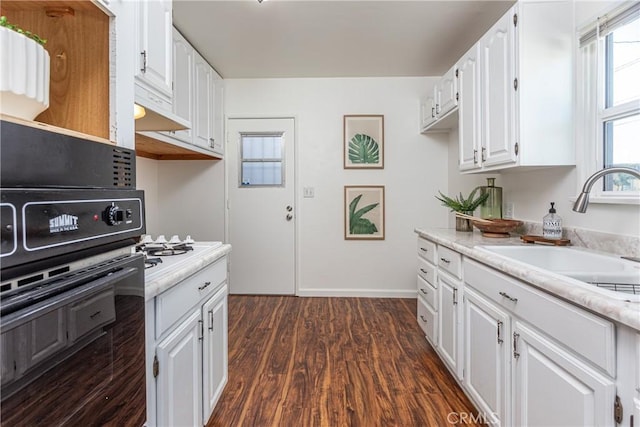 kitchen featuring dark wood-type flooring, sink, white cabinetry, white gas cooktop, and black oven