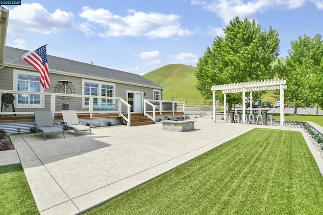 exterior space with a patio, a pergola, a yard, an outdoor fire pit, and a deck with mountain view