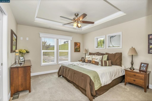 carpeted bedroom featuring crown molding, ceiling fan, and a raised ceiling