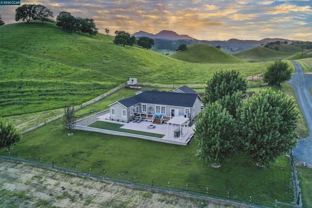 aerial view at dusk with a mountain view and a rural view