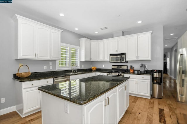 kitchen featuring white cabinetry, stainless steel appliances, a center island, and sink