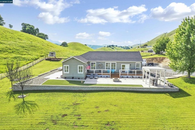 back of property featuring a patio area, a gazebo, a yard, a mountain view, and an outdoor living space