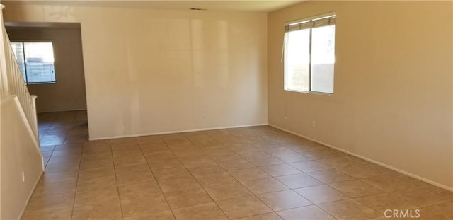 empty room with light tile patterned flooring and a healthy amount of sunlight