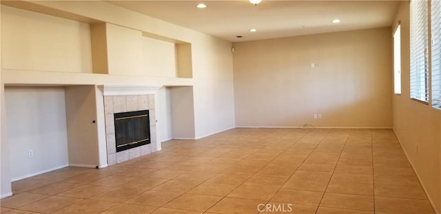 unfurnished living room featuring a tiled fireplace and light tile patterned floors