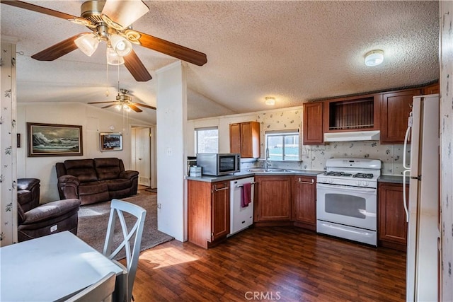 kitchen with dark hardwood / wood-style flooring, sink, white appliances, and vaulted ceiling