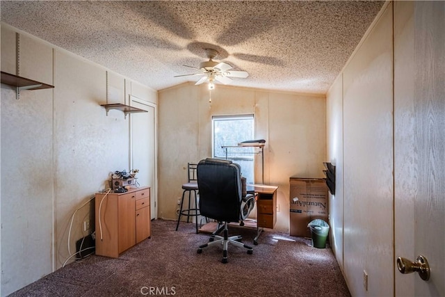 office space with ceiling fan, lofted ceiling, dark carpet, and a textured ceiling