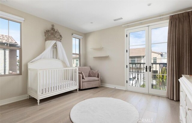 bedroom with access to outside, light hardwood / wood-style flooring, and french doors