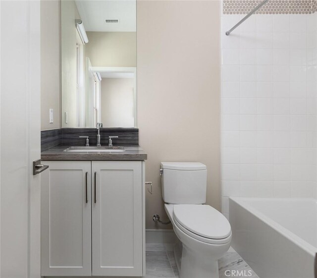 full bathroom with vanity, toilet, and tiled shower / bath combo