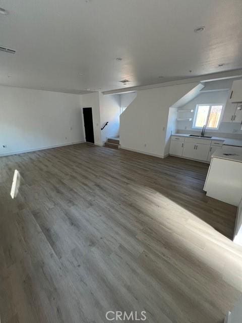 bonus room with dark hardwood / wood-style flooring and sink