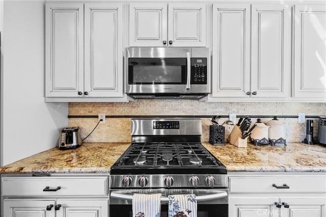 1430 Sequoia Dr, Lake Arrowhead, CA 92352 - kitchen featuring appliances with stainless steel finishes, white cabinets, decorative backsplash, and light stone counters