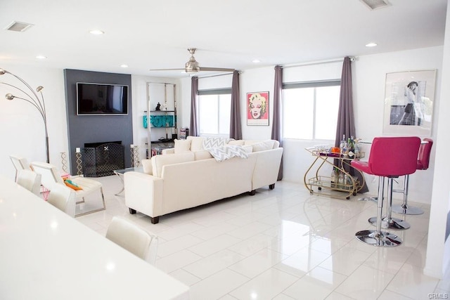 living room with ceiling fan and a large fireplace