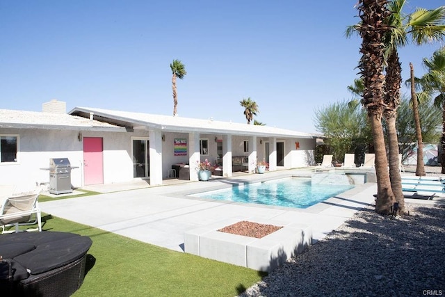 view of pool with area for grilling and a patio