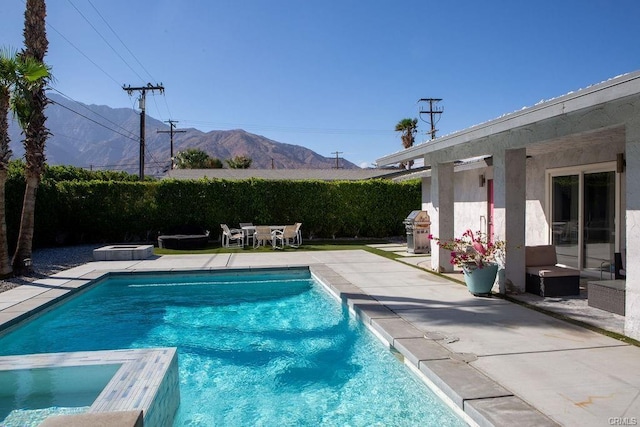 view of pool with grilling area, a patio, a mountain view, and an in ground hot tub