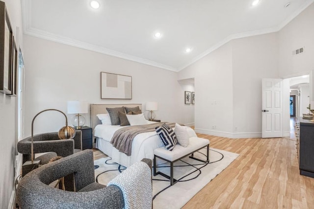 bedroom with high vaulted ceiling, ornamental molding, and light hardwood / wood-style floors