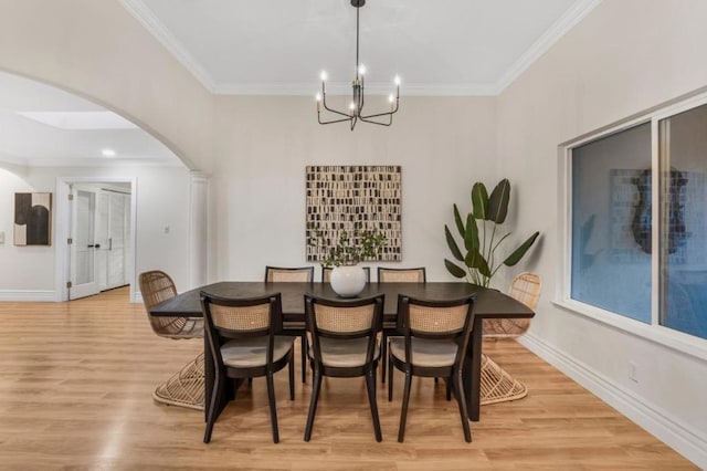 dining room with a notable chandelier, light hardwood / wood-style flooring, and ornamental molding