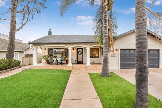 view of front of property featuring a garage, covered porch, and a front yard