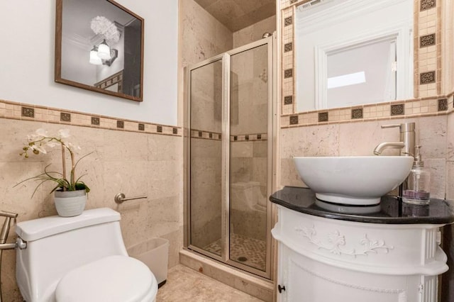 bathroom featuring toilet, an enclosed shower, sink, tile walls, and tile patterned flooring