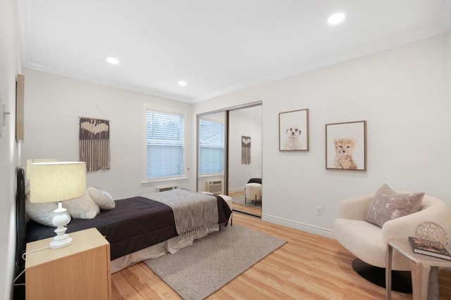 bedroom featuring crown molding, light hardwood / wood-style floors, and a closet