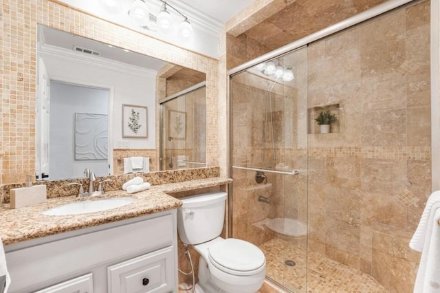 bathroom with a shower with door, crown molding, vanity, and toilet