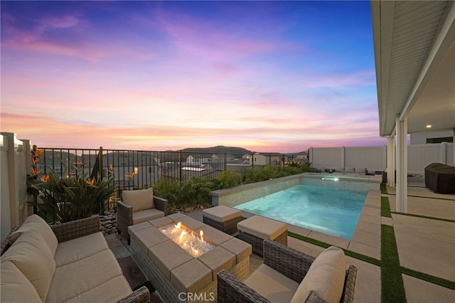 pool at dusk featuring a fire pit and a patio