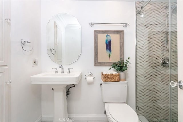 bathroom featuring sink, toilet, and a shower with door