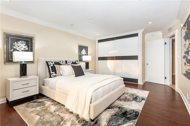 bedroom with crown molding, dark hardwood / wood-style flooring, and a closet