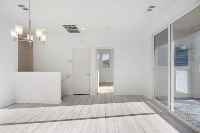 interior space with a notable chandelier and light hardwood / wood-style floors