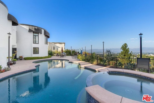 view of pool with an in ground hot tub and a patio