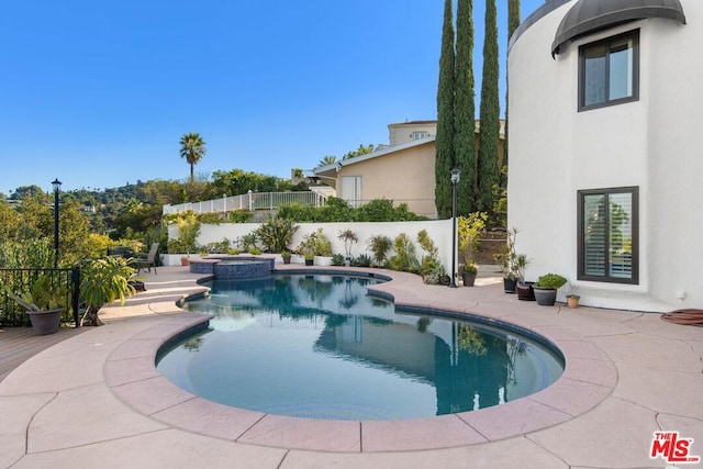 view of swimming pool with an in ground hot tub and a patio