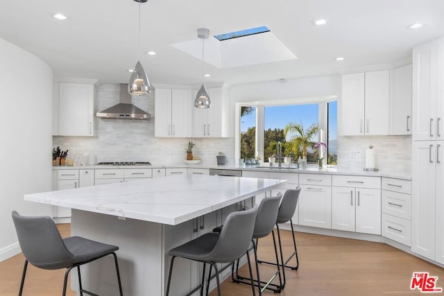 kitchen with hanging light fixtures, a breakfast bar area, and white cabinets