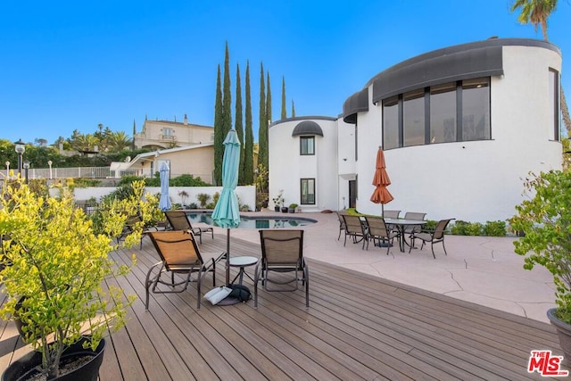 wooden terrace with a fenced in pool