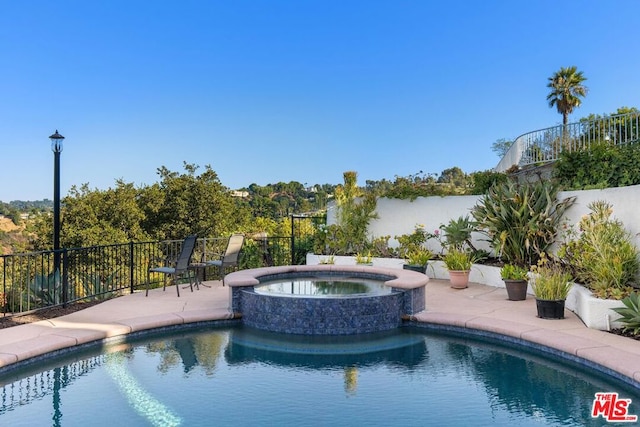 view of swimming pool with a patio and an in ground hot tub