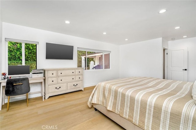 bedroom featuring multiple windows and light hardwood / wood-style flooring