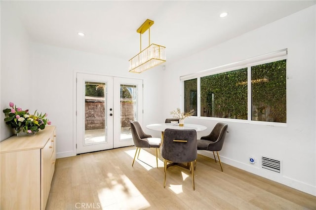 dining area featuring light wood-type flooring and french doors