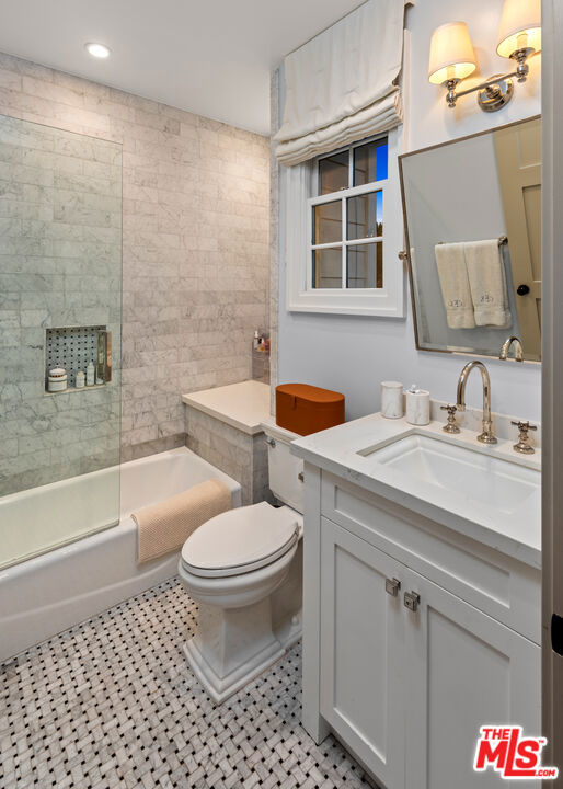 full bathroom featuring tile patterned flooring, enclosed tub / shower combo, vanity, and toilet