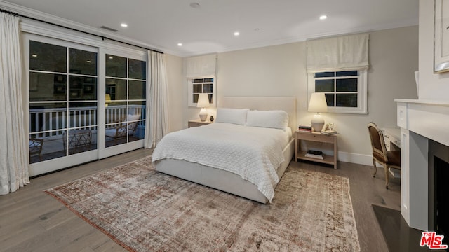 bedroom with crown molding, hardwood / wood-style floors, and access to exterior