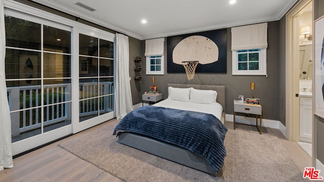 bedroom featuring hardwood / wood-style flooring, ornamental molding, access to outside, and ensuite bath