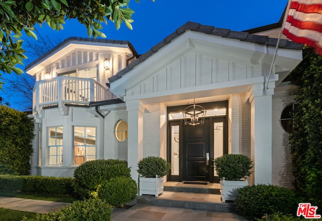 doorway to property featuring a balcony and covered porch