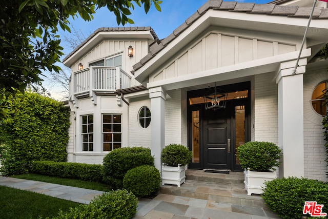 property entrance featuring a balcony and a porch