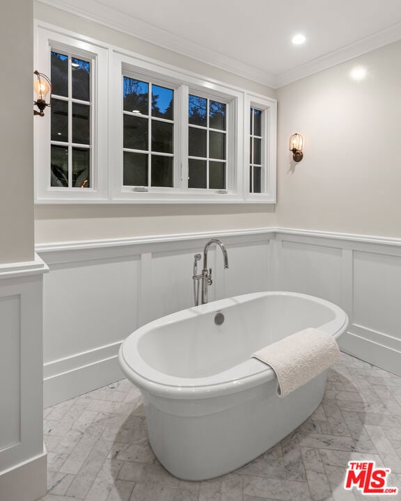 bathroom featuring ornamental molding and a bathing tub