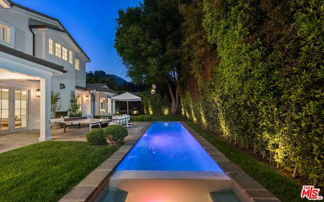 view of pool featuring french doors, a yard, and a patio