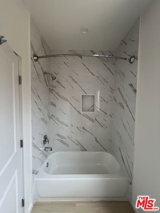 bathroom featuring tiled shower / bath combo and hardwood / wood-style flooring