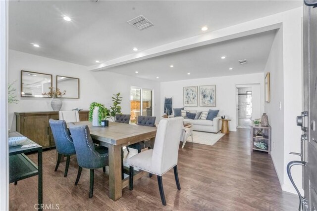 dining area with beam ceiling and dark wood-type flooring