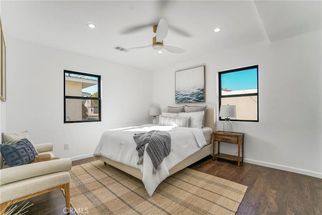 bedroom featuring dark wood-type flooring, ceiling fan, and multiple windows