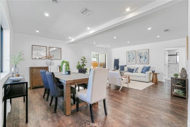 dining area featuring beamed ceiling and dark wood-type flooring