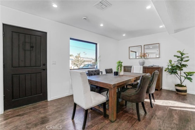 dining space with beamed ceiling and dark hardwood / wood-style floors