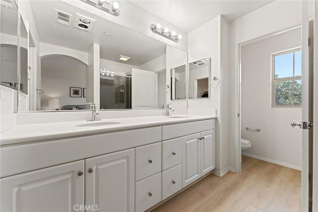 bathroom featuring vanity, toilet, and hardwood / wood-style floors